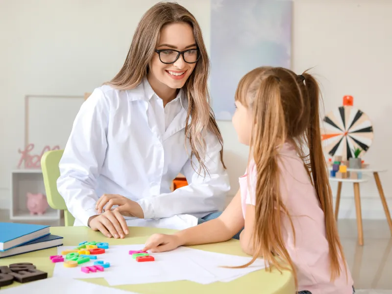 crea gabinete Terapeuta trabajando con una niña con material didáctico